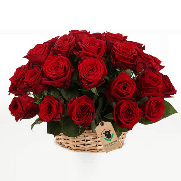 Red roses arrangement displayed in a small woven cane basket
