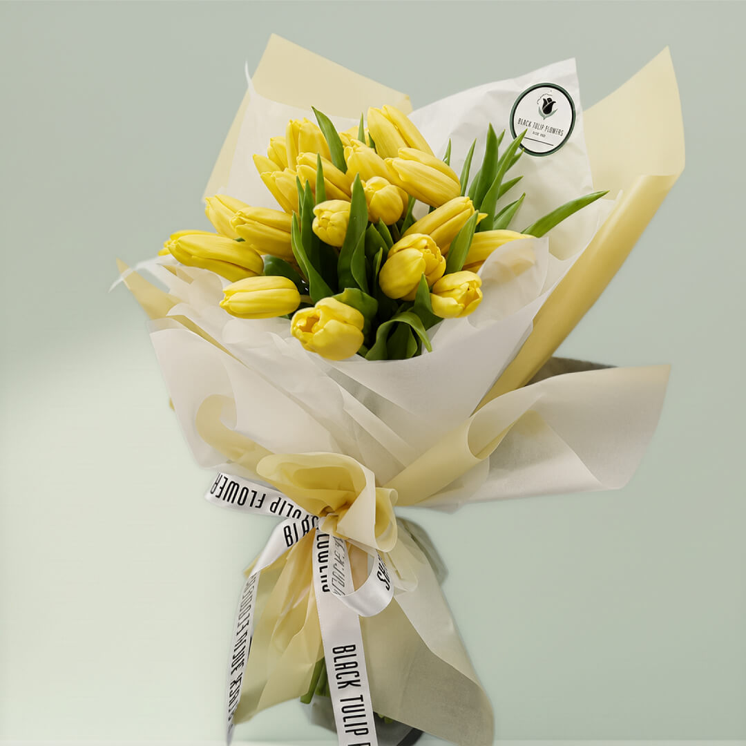 Blossoms of yellow tulips in full bloom, showcasing vibrant yellow petals and fresh green stems.