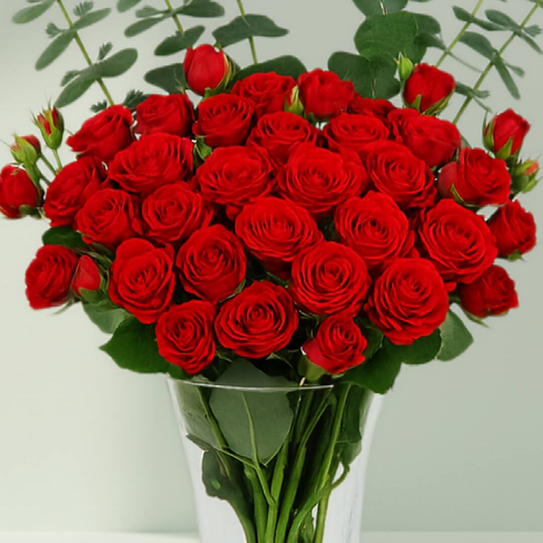 Red Roses in Glass Vase arranged with 20 red roses and eucalyptus