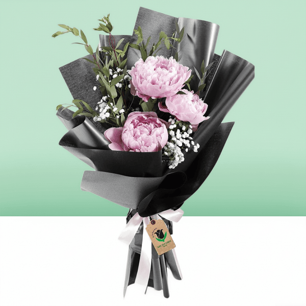 Pink peonies bouquet with baby’s breath and greenery in black non-woven wrapping