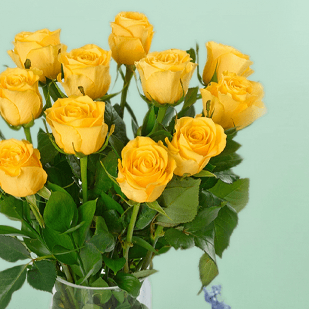 Vase arrangement with 20 yellow roses and fresh greenery in a transparent cylinder glass vase.