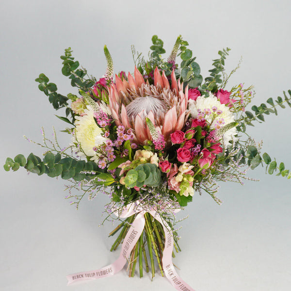 Assorted bouquet with King Protea, Spray Roses, Disbud Chrysanthemums, Veronica, Snapdragons and fresh greenery.