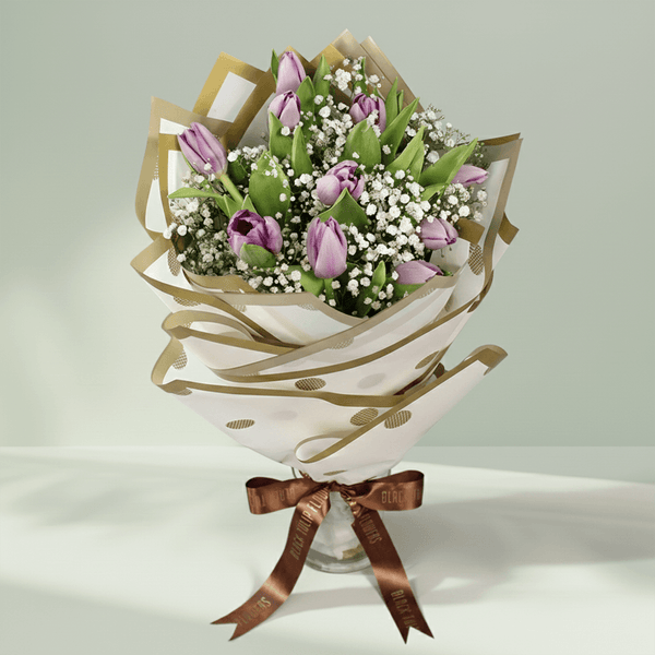 Purple tulip bouquet with baby’s breath, green foliage and elegant gold-accented wrapping.