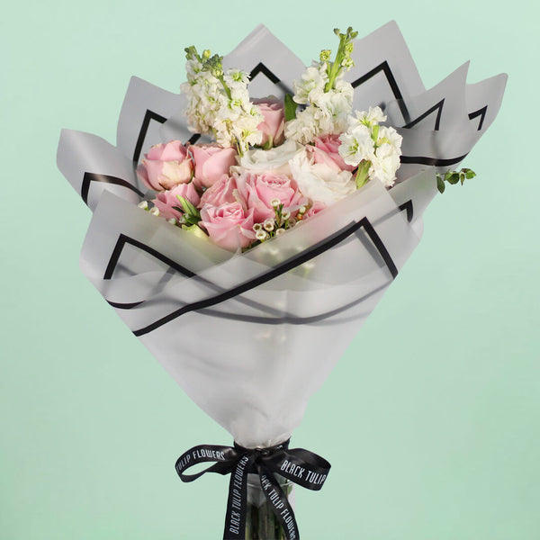 Pink Roses, white Eustoma, Snapdragons and Wax Flowers wrapped in white Korean-style flower sheets.