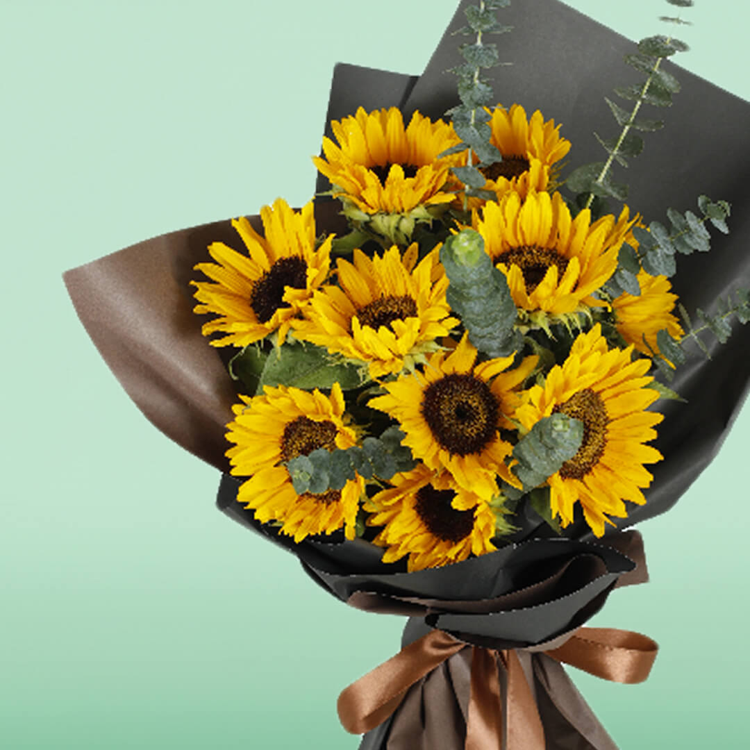 Bright yellow sunflower bouquet with eucalyptus wrapped in black and brown Korean-style flower wrapping sheets