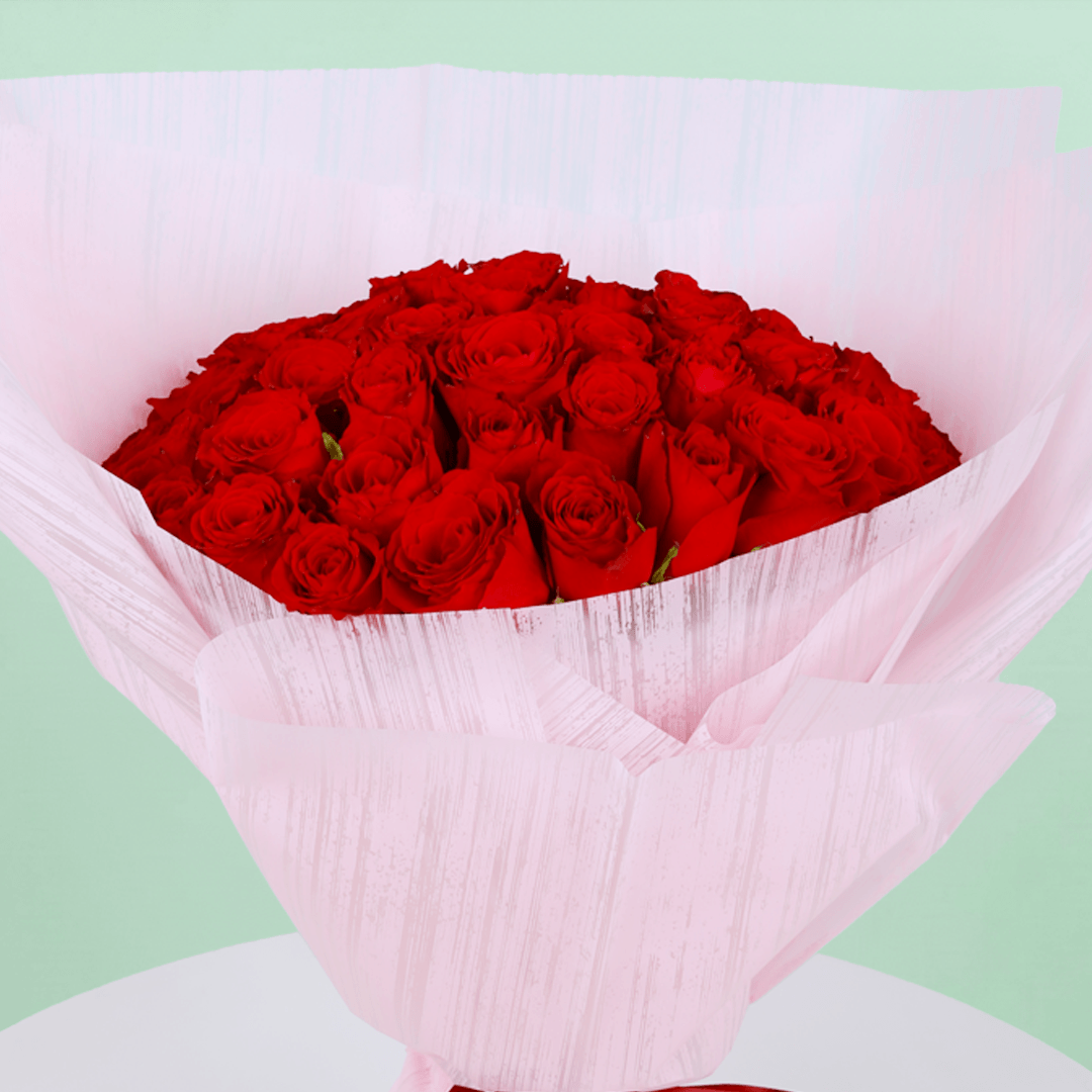 A bouquet of 40 red roses in pink wrap