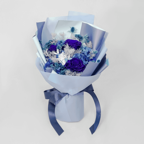 Blue preserved flower bouquet arranged with decorative dried blooms and fillers.