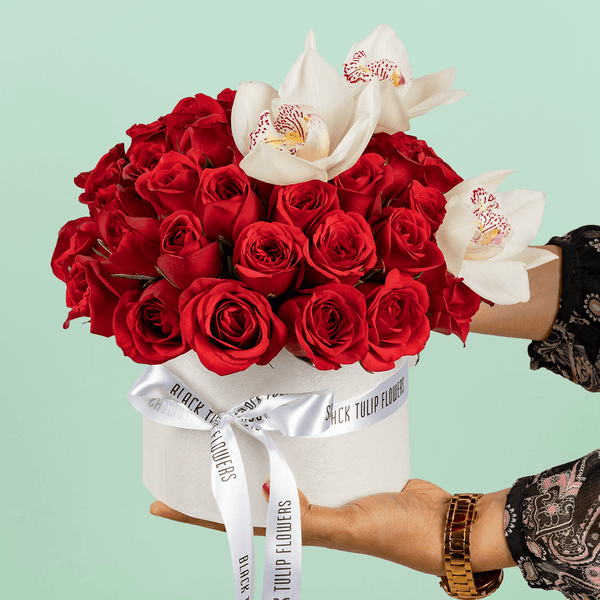 50 Red Roses & White Orchid Box arranged with 50 red roses, white cymbidium orchids and fresh foliage
