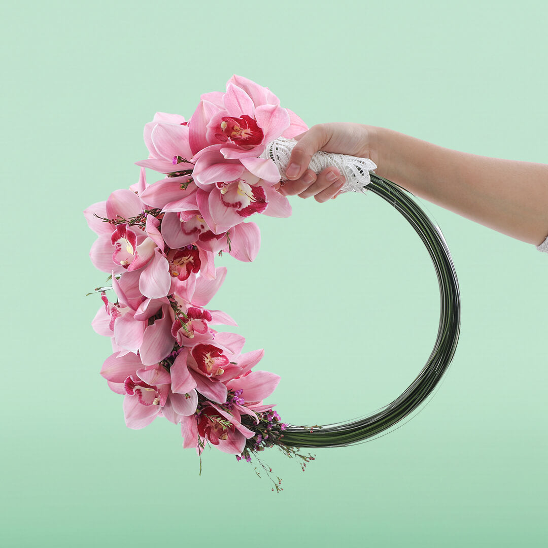 Elegant circular bridal hoop with pink Cymbidium orchids and wax flowers