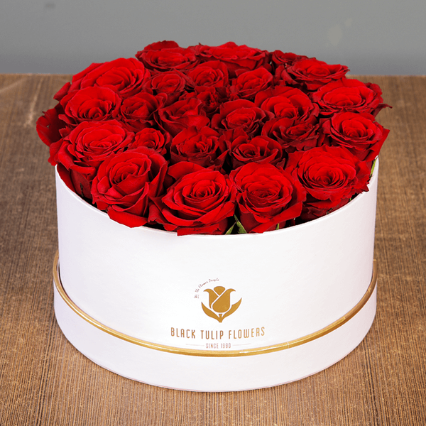 Round flower box featuring 25 to 35 red roses in a premium white box with gold detailing