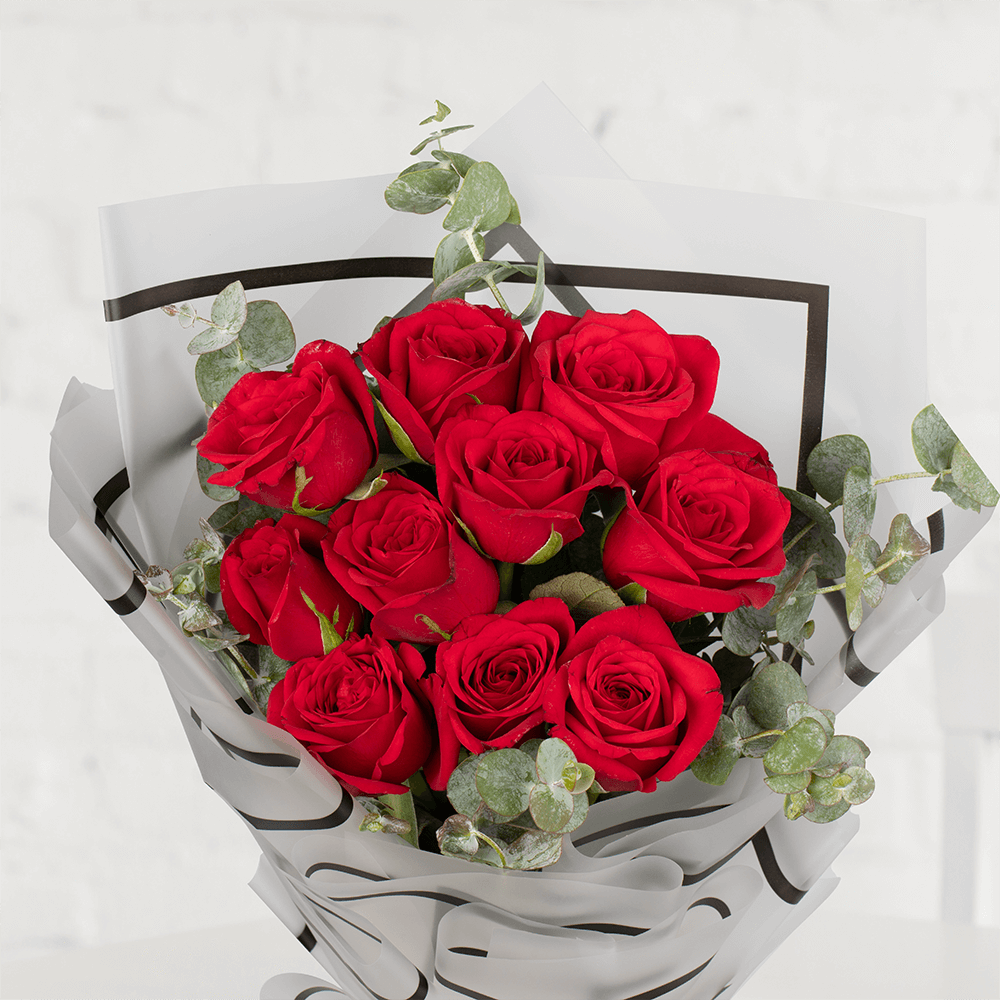 Red roses with eucalyptus greenery wrapped in layered grey paper