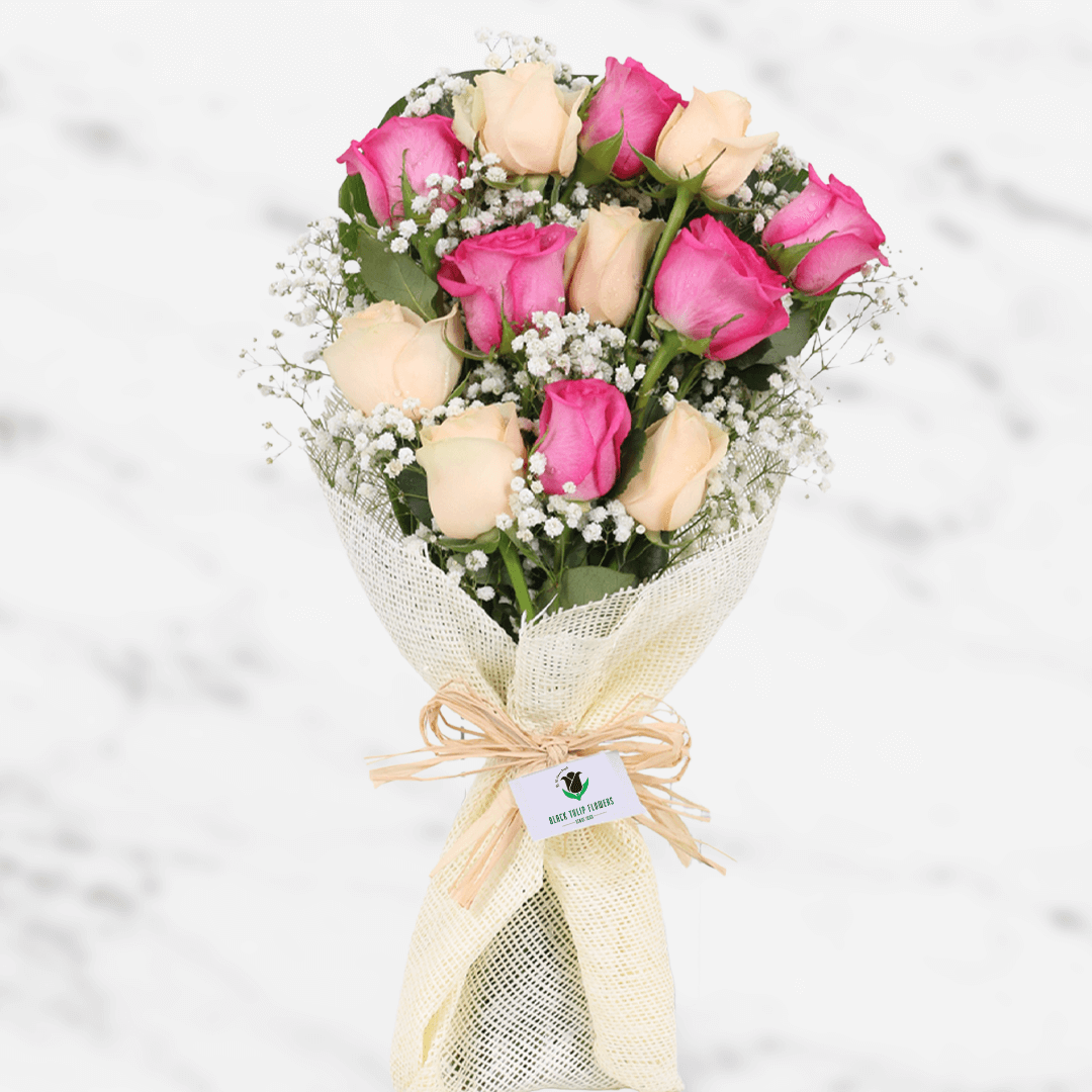 A pastel bouquet of pink and peach roses with fillers in non woven paper wrap.
