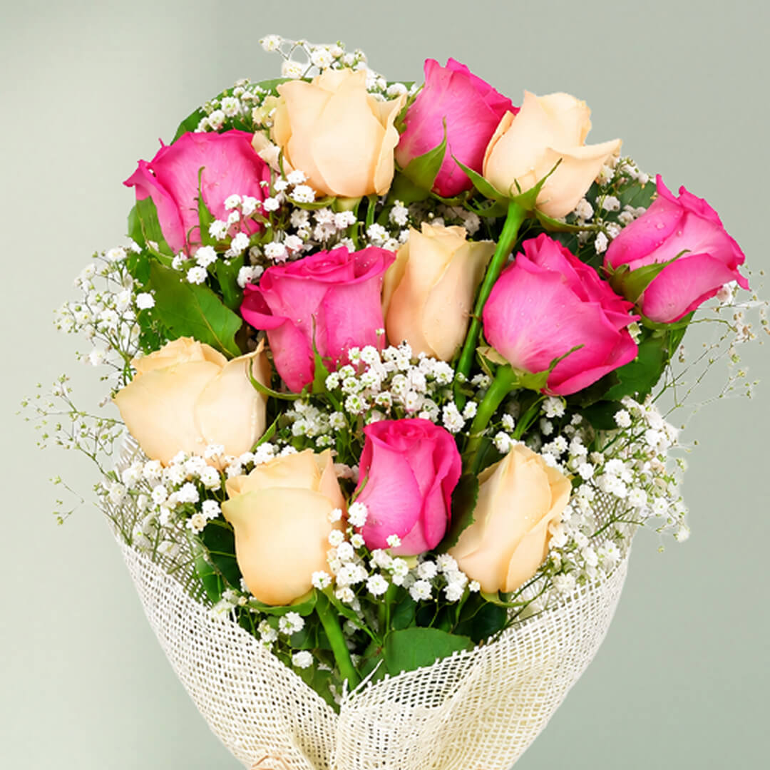 12 stem pink and peach rose bouquet with fillers wrapped in non-woven paper