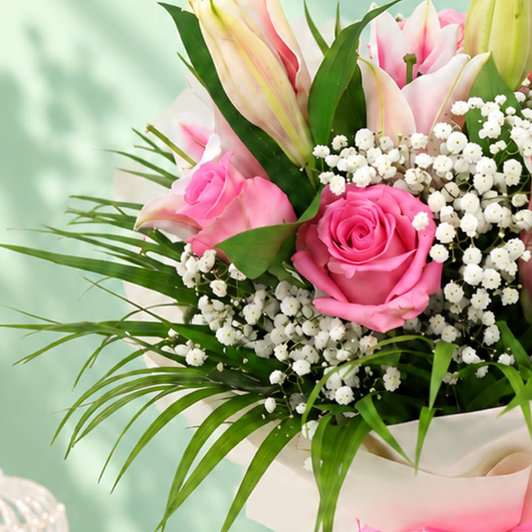 7-stem bouquet of pink lilies and roses with delicate gypso flowers and green leaves