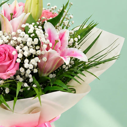 7-stem bouquet of pink lilies and roses with delicate gypso flowers and green leaves