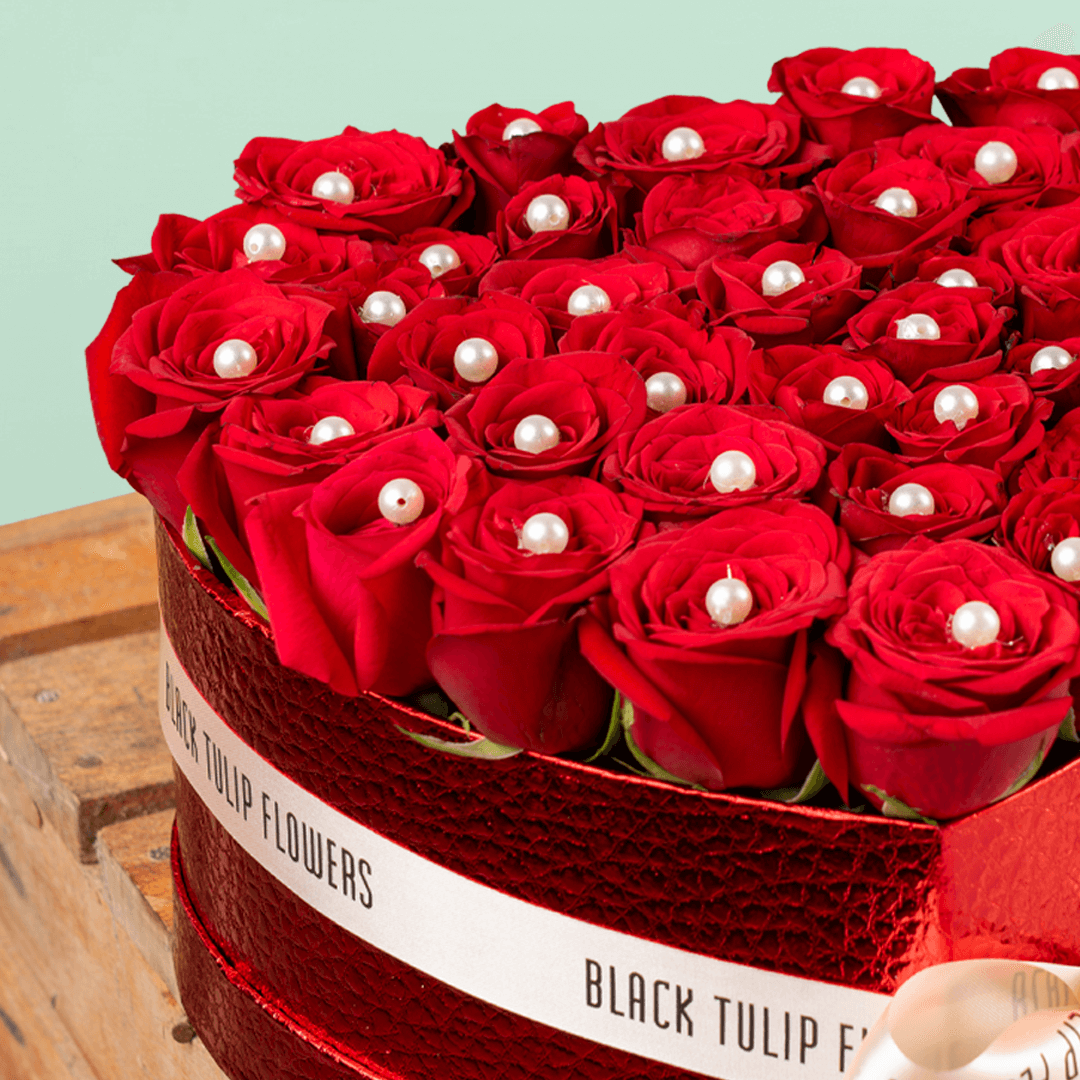 Heart shaped red rose box with pearl accents and ribbon detailing