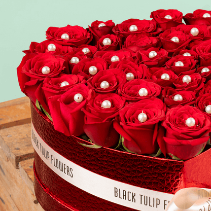 Heart shaped red rose box with pearl accents and ribbon detailing