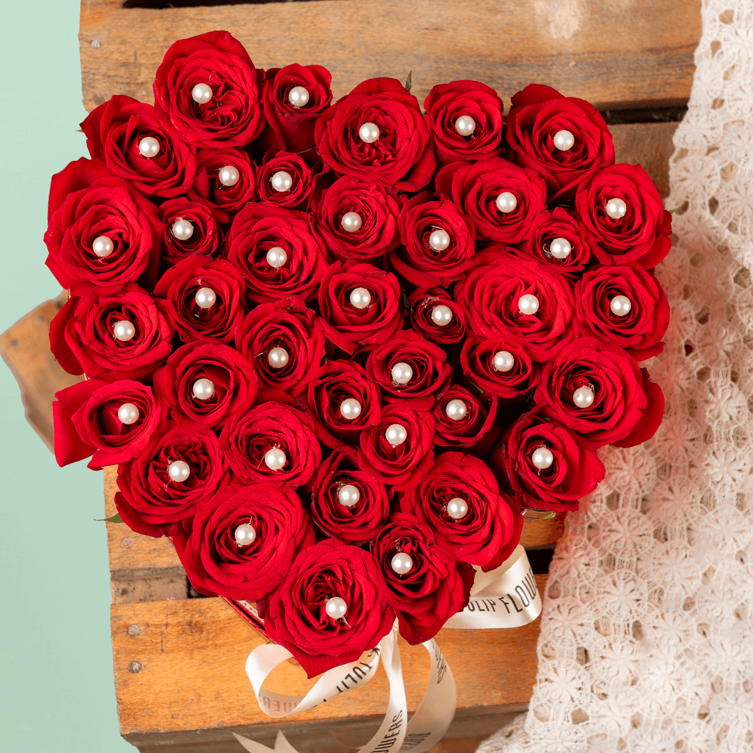 Heart shaped red rose box with pearl accents and ribbon detailing