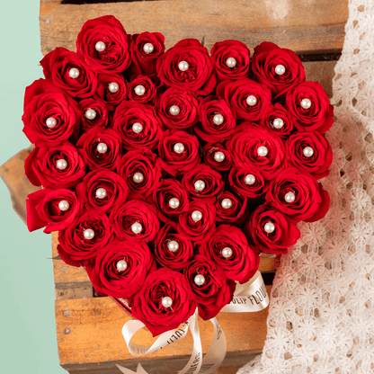 Heart shaped red rose box with pearl accents and ribbon detailing
