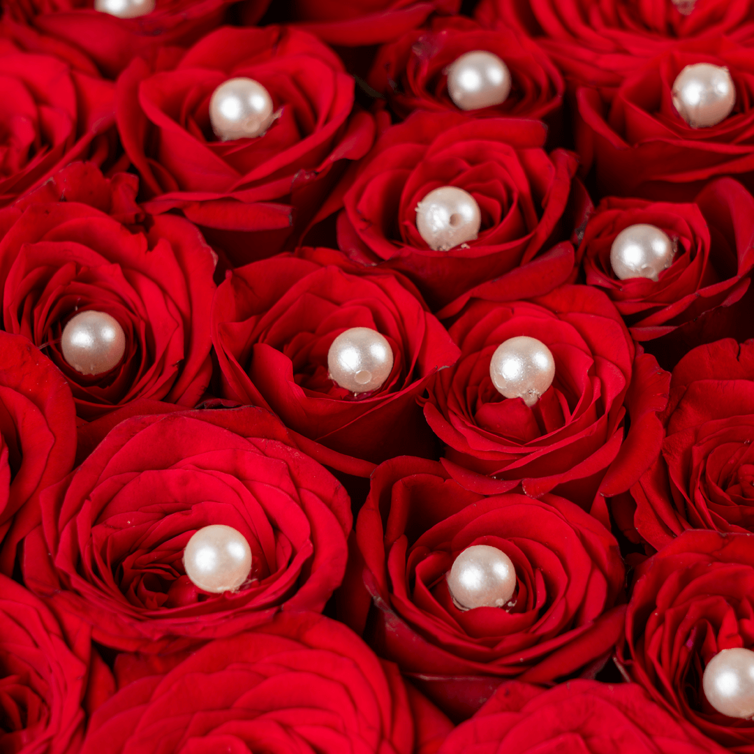 Heart shaped red rose box with pearl accents and ribbon detailing