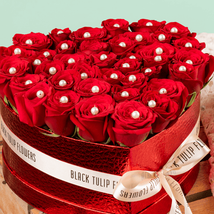 Heart shaped red rose box with pearl accents and ribbon detailing
