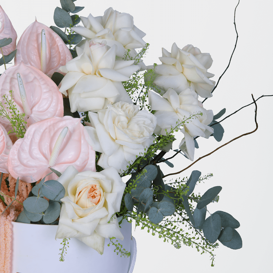 Assorted White Roses and Carnations with berries and greenery arranged in a glossy round flower box.
of harmony - Image 3