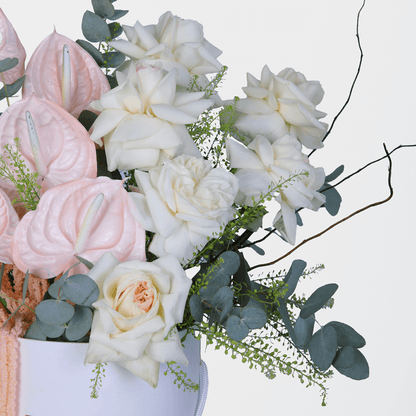 Assorted White Roses and Carnations with berries and greenery arranged in a glossy round flower box.
of harmony - Image 3