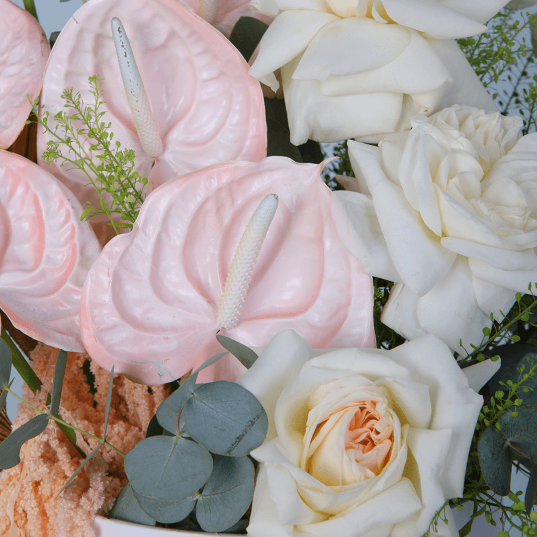 White Roses and Carnations with berries and greenery arranged in a glossy round flower box.