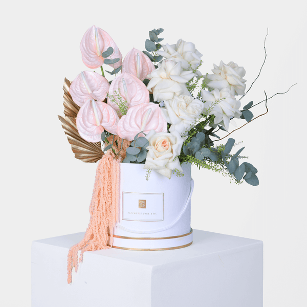 White Roses and Carnations with berries and greenery arranged in a glossy round flower box.