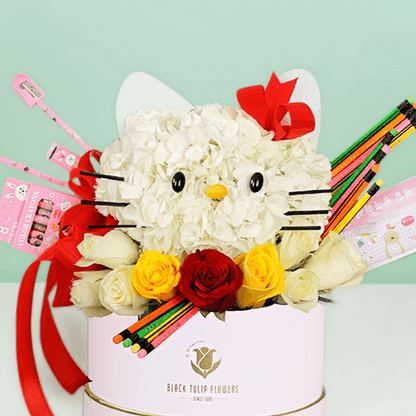 Round flower box featuring roses and hydrangeas in a Hello Kitty-inspired design, decorated with colourful stationery items.