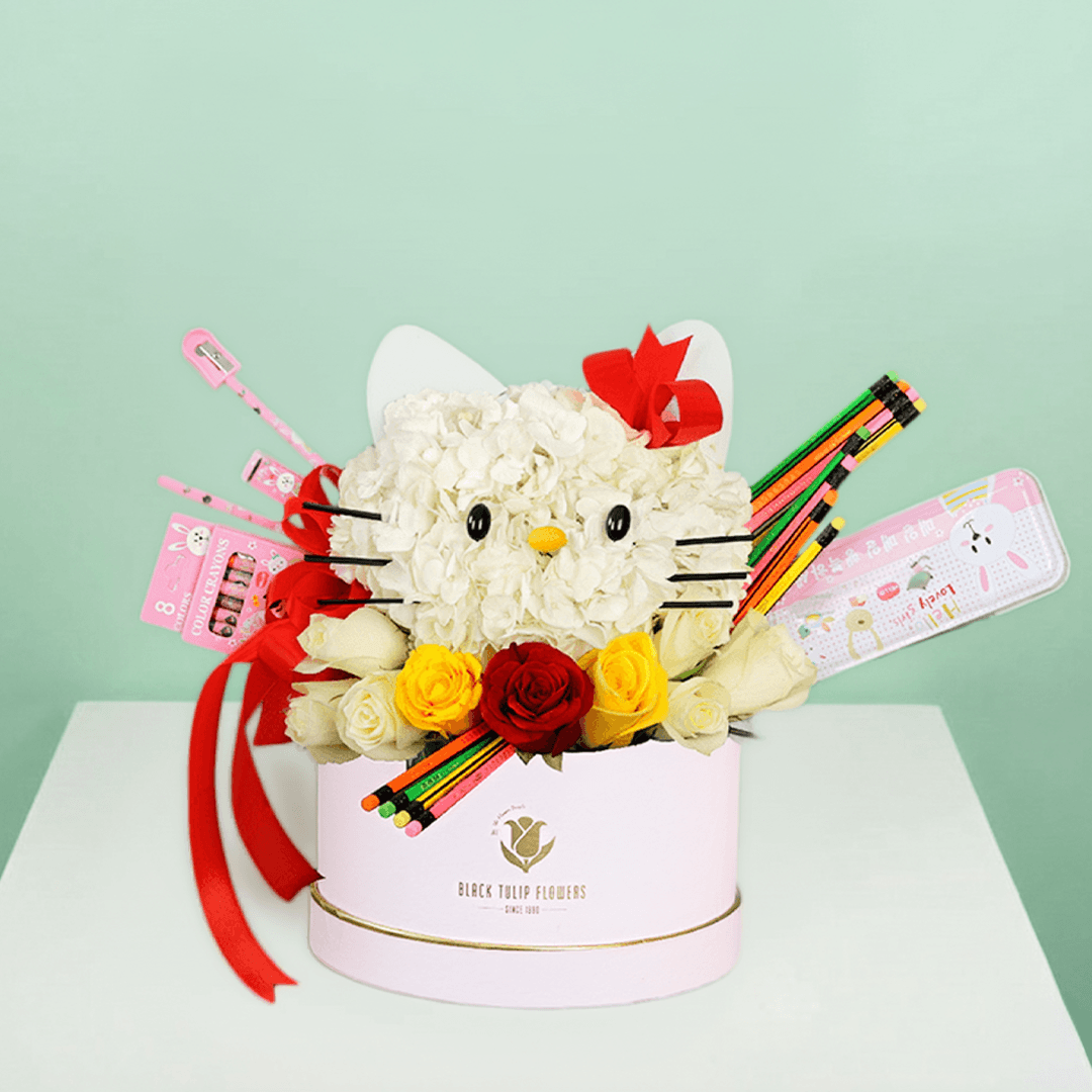 Round flower box featuring roses and hydrangeas in a Hello Kitty-inspired design, decorated with colourful stationery items.