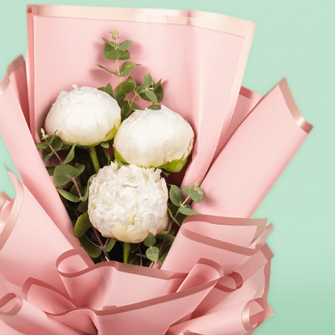 White peonies with green fillers wrapped in Korean-style flower wrapping sheets.