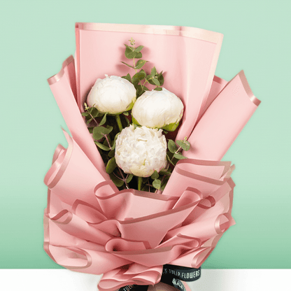 White peonies with green fillers wrapped in Korean-style flower wrapping sheets.