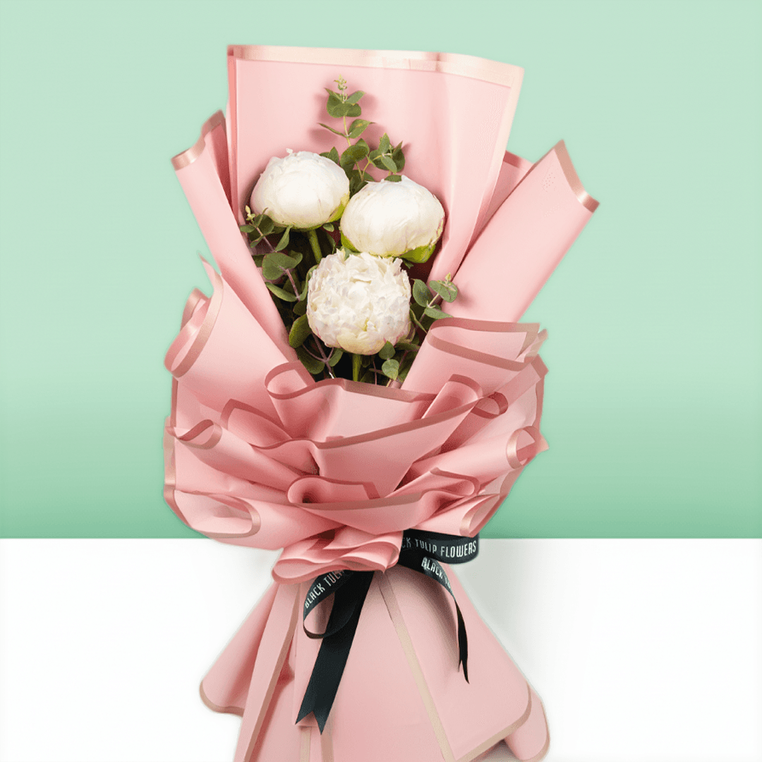 White peonies with green fillers wrapped in Korean-style flower wrapping sheets.