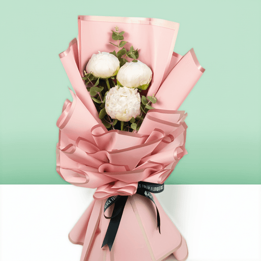 White peonies with green fillers wrapped in Korean-style flower wrapping sheets.