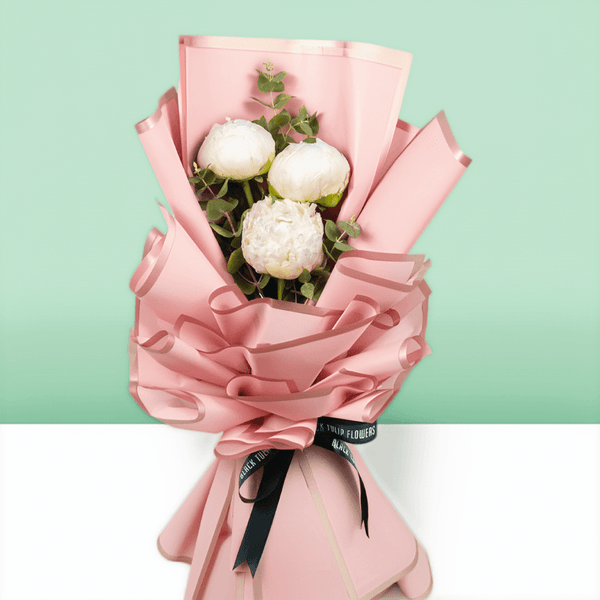 White peonies with green fillers wrapped in Korean-style flower wrapping sheets.