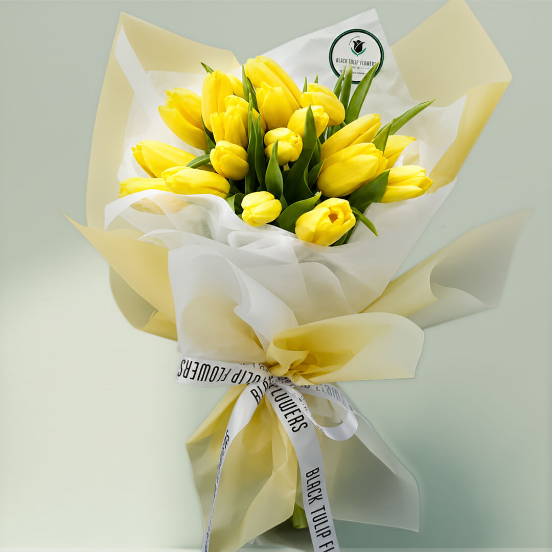 Blossoms of yellow tulips in full bloom, showcasing vibrant yellow petals and fresh green stems.