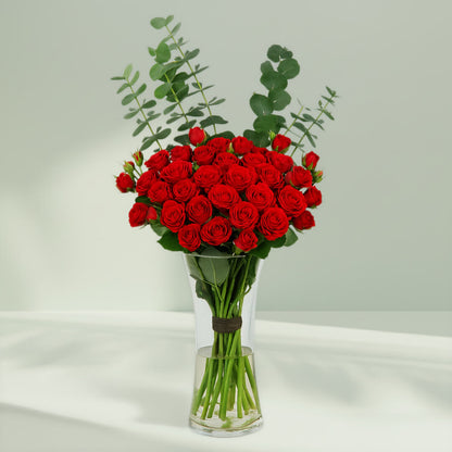 Red Roses in Glass Vase arranged with 20 red roses and eucalyptus