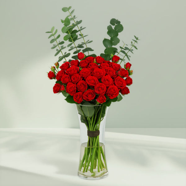 Red Roses in Glass Vase arranged with 20 red roses and eucalyptus