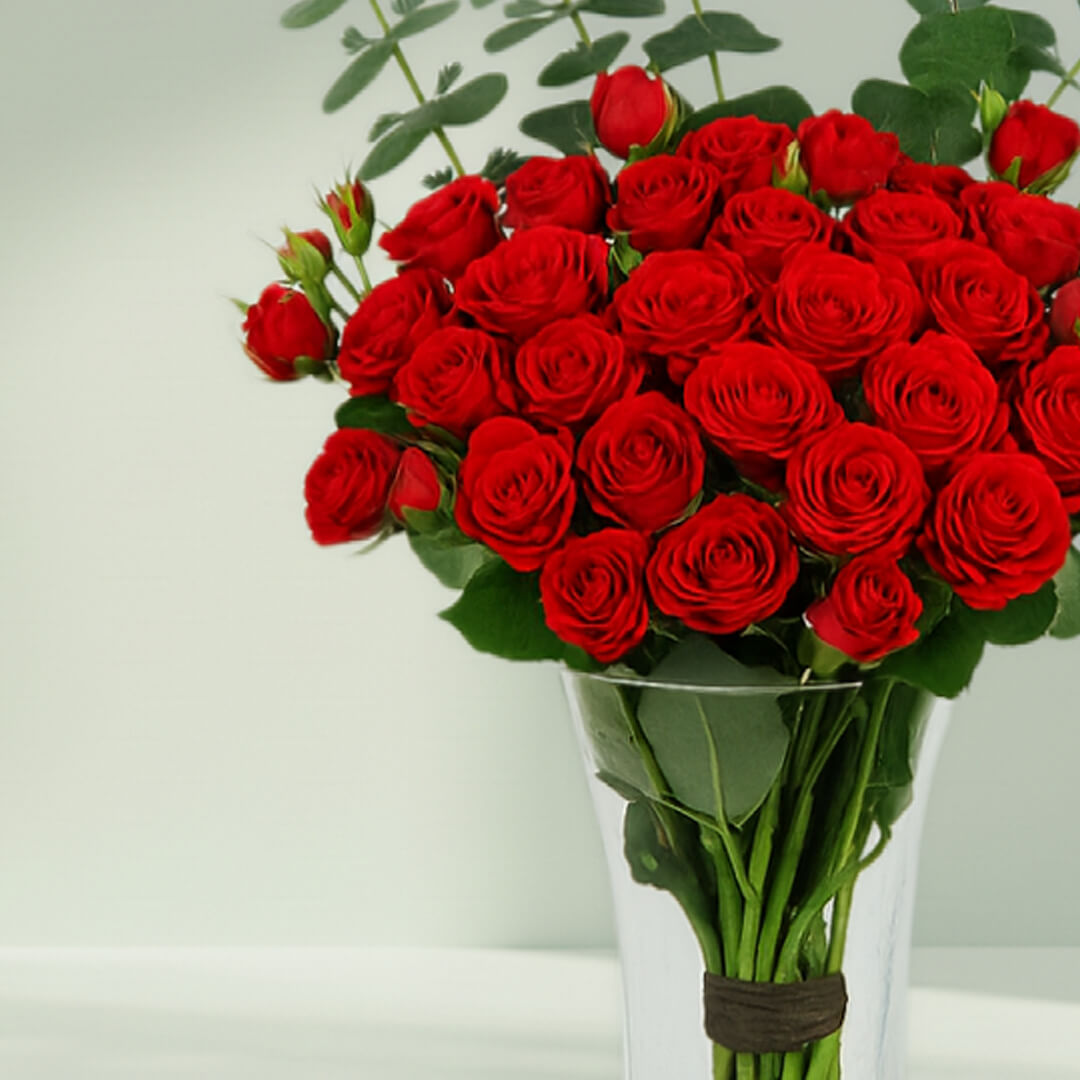 Red Roses in Glass Vase arranged with 20 red roses and eucalyptus