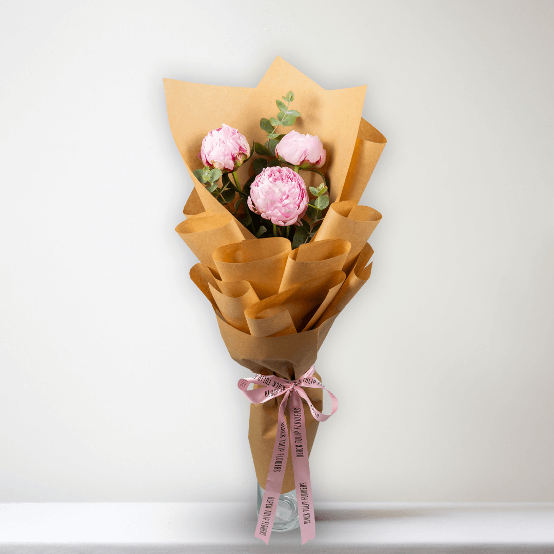 Pink peonies with green fillers wrapped in Korean-style flower wrapping sheets.