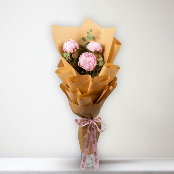 Pink peonies with green fillers wrapped in Korean-style flower wrapping sheets.