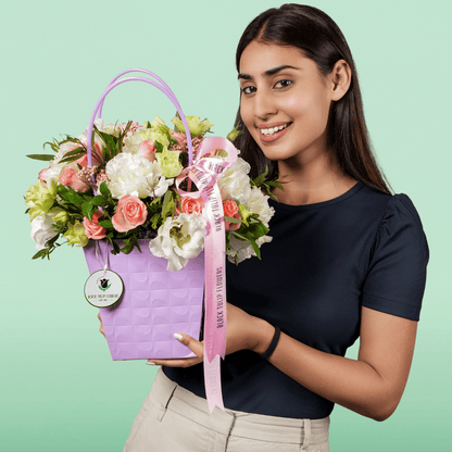 White and pink Disbud Chrysanthemum, Eustoma and Hypericum arrangement in a lavender flower gift bag.