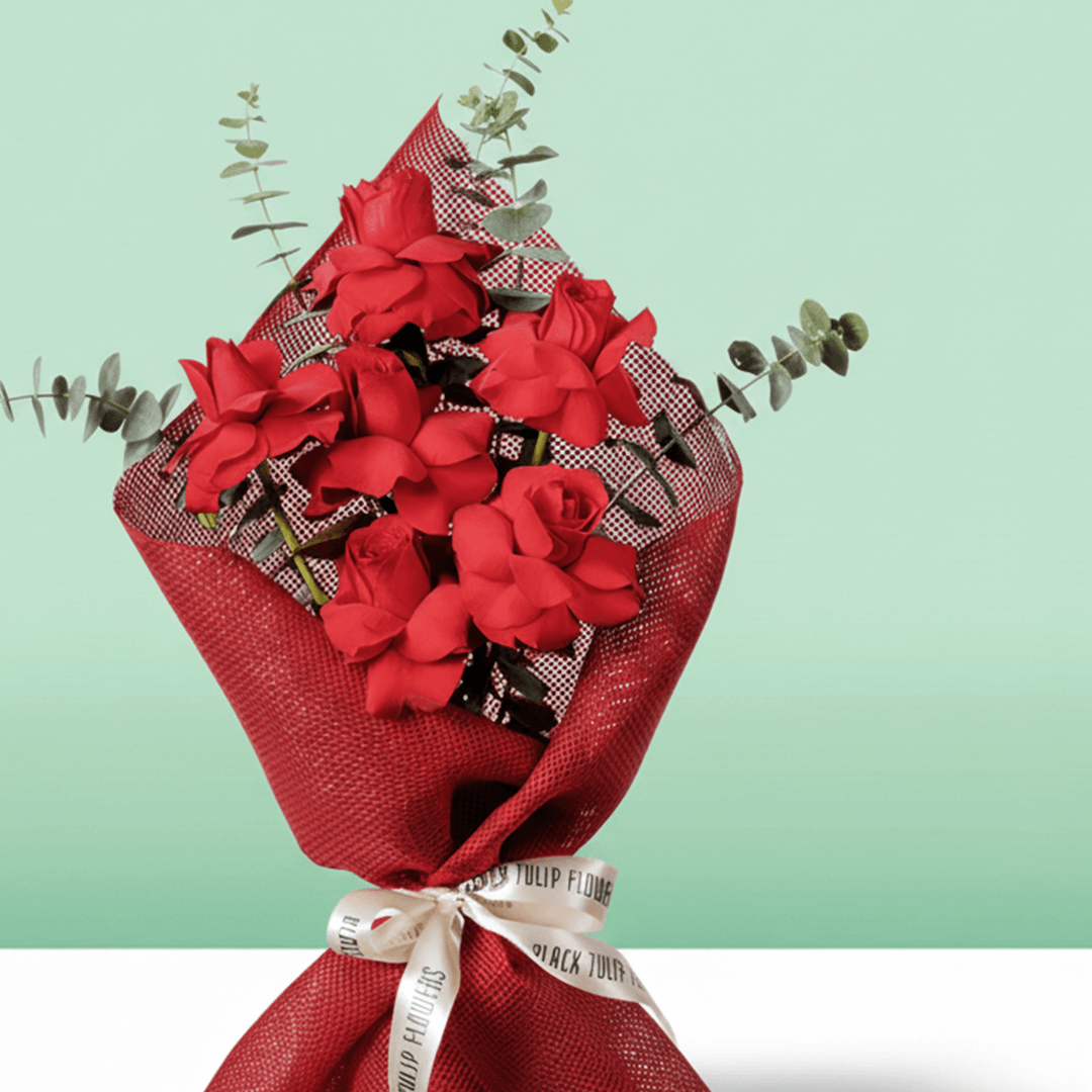 Red roses bouquet with eucalyptus in red wrapping.