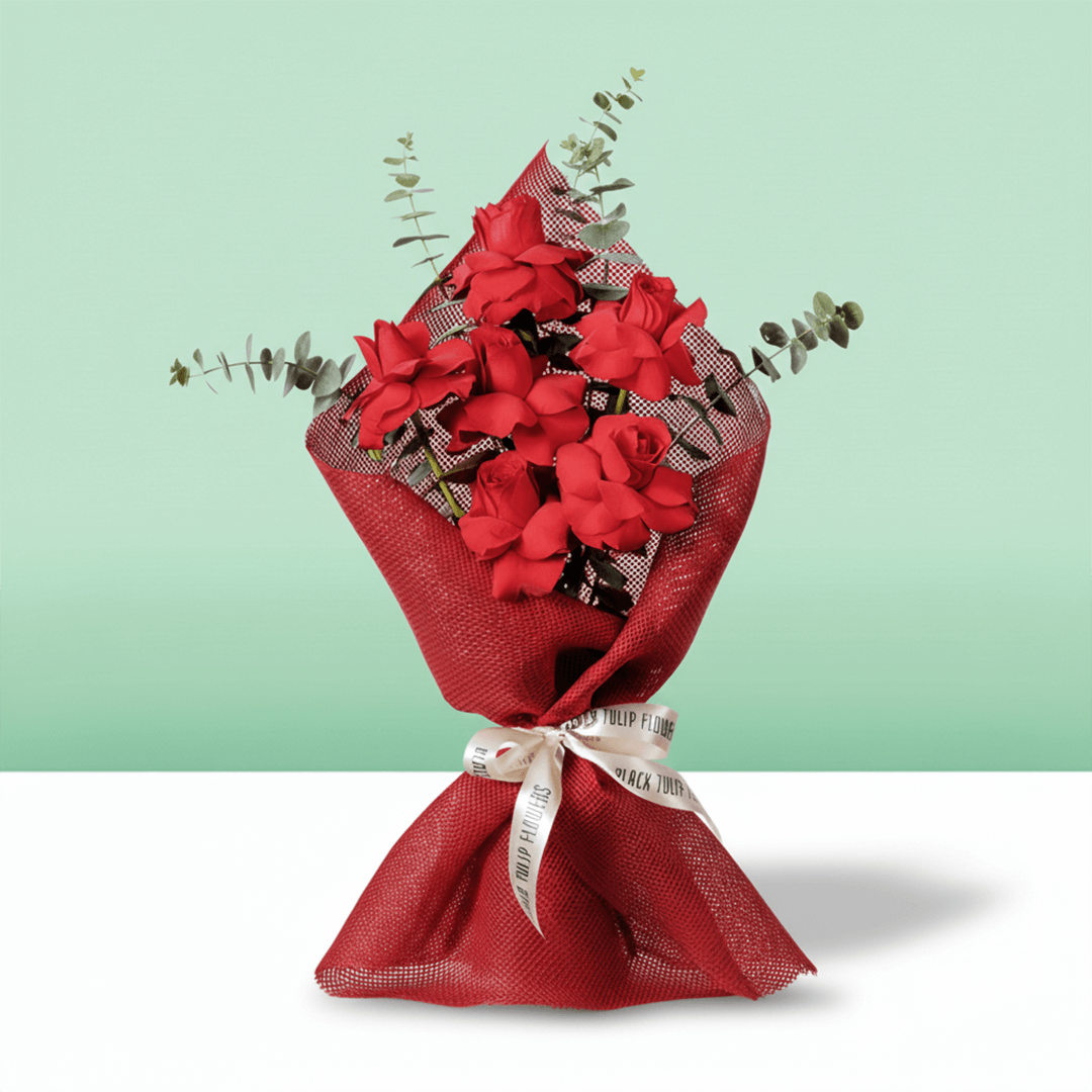 Red roses bouquet with eucalyptus in red wrapping.