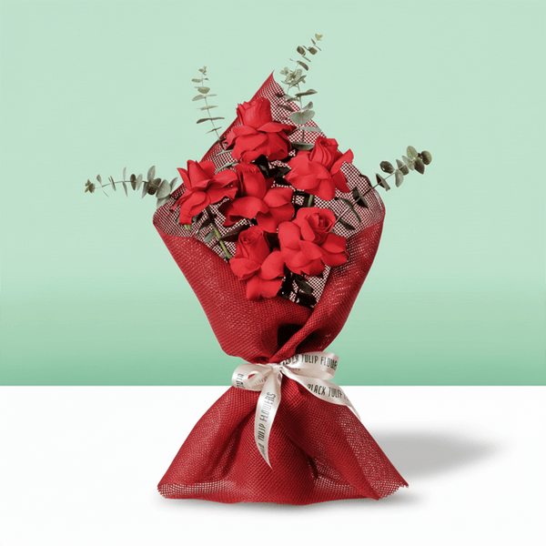 Red roses bouquet with eucalyptus in red wrapping.