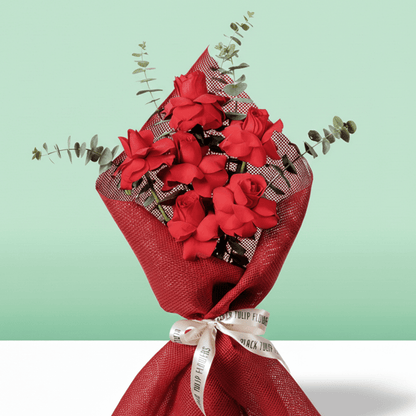 Red roses bouquet with eucalyptus in red wrapping.