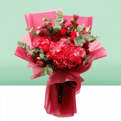 Pink hydrangea, red spray roses and ping pong chrysanthemums bouquet with eucalyptus in bright pink wrapping