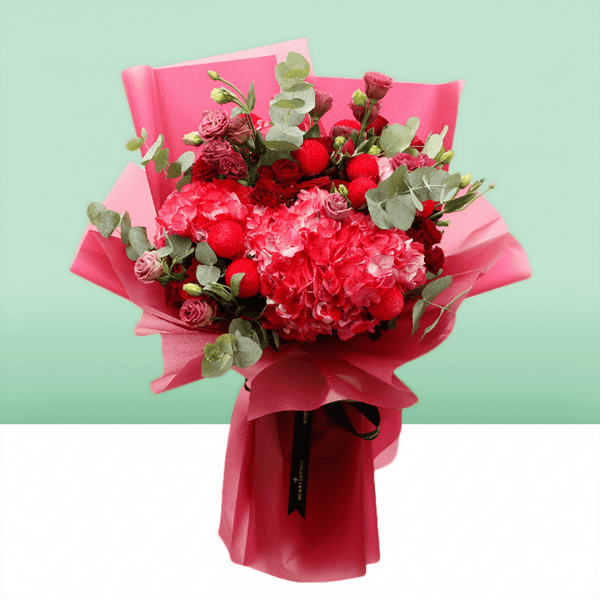 Pink hydrangea, red spray roses and ping pong chrysanthemums bouquet with eucalyptus in bright pink wrapping