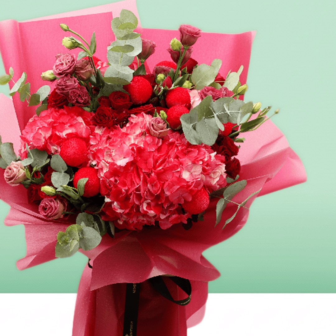 Pink hydrangea, red spray roses and ping pong chrysanthemums bouquet with eucalyptus in bright pink wrapping